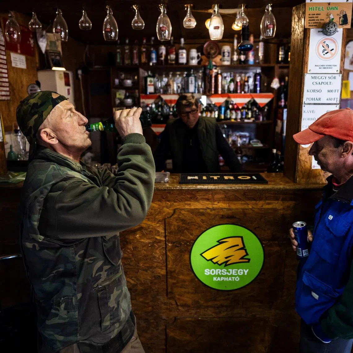 Sandor Toth, owner of Sanyi's Pub, talks to customers in Malyinka, Hungary, March 23, 2026. REUTERS/Marton Monus