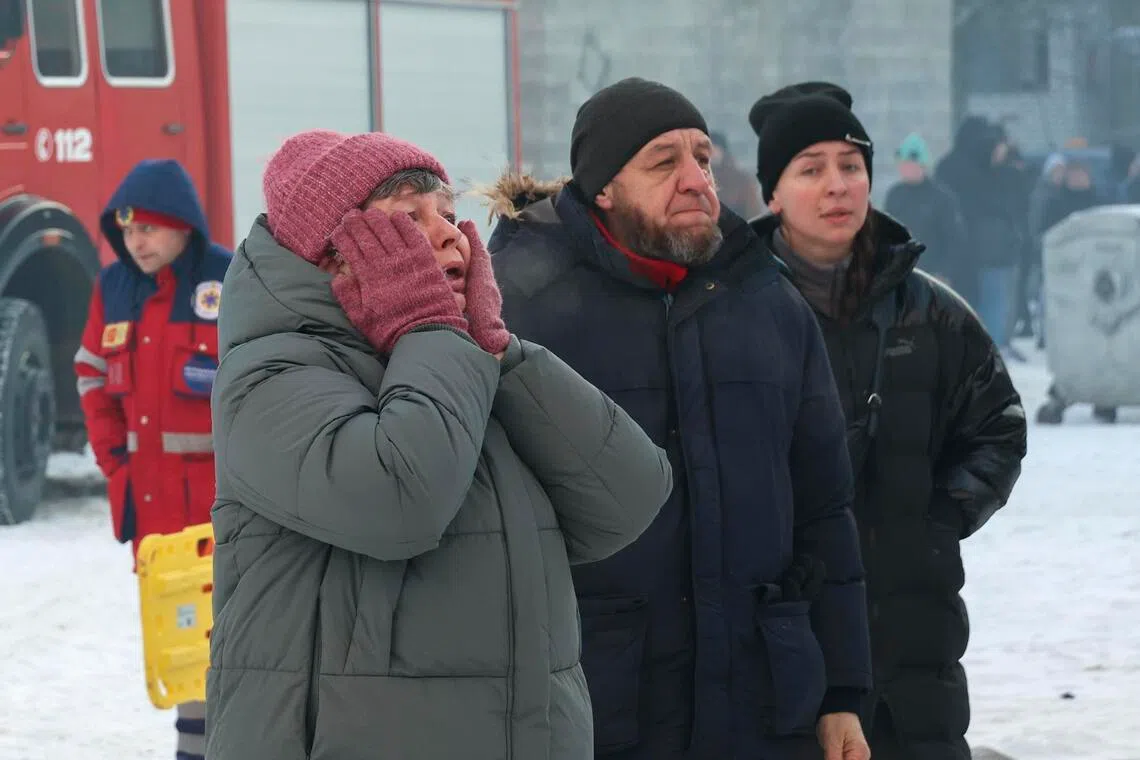 Local people reacting near the site of a Russian drone strike on a residential building in Kharkiv, northeastern Ukraine, on Feb 3.