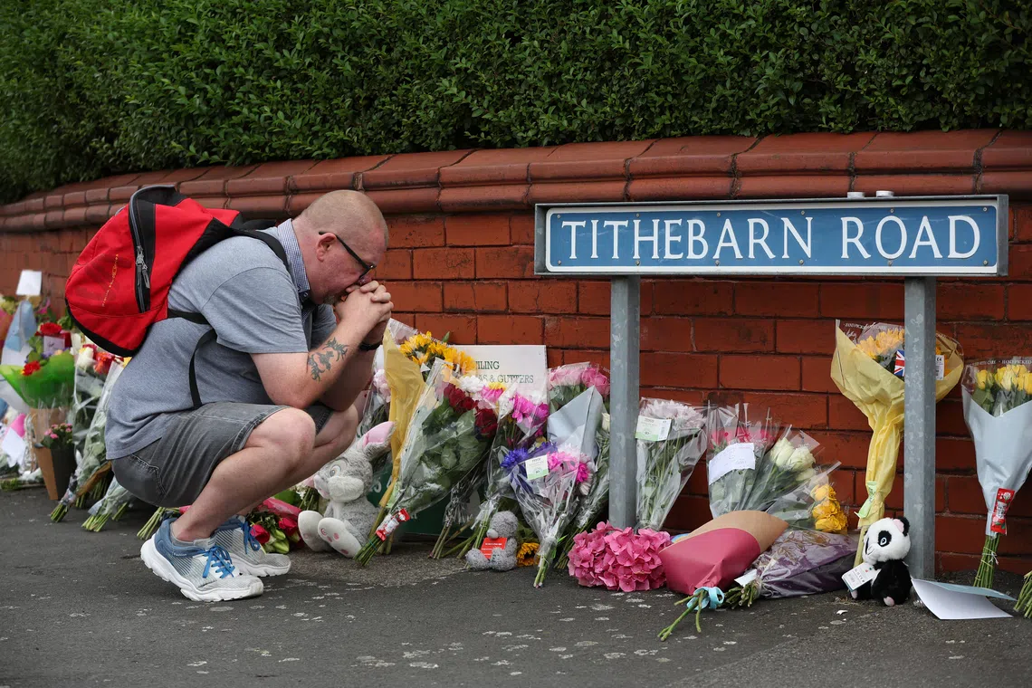 A person looks at flowers and tributes at the scene of a stabbing attack near Hart Street in Southport, Britain, on July 30, 2024.