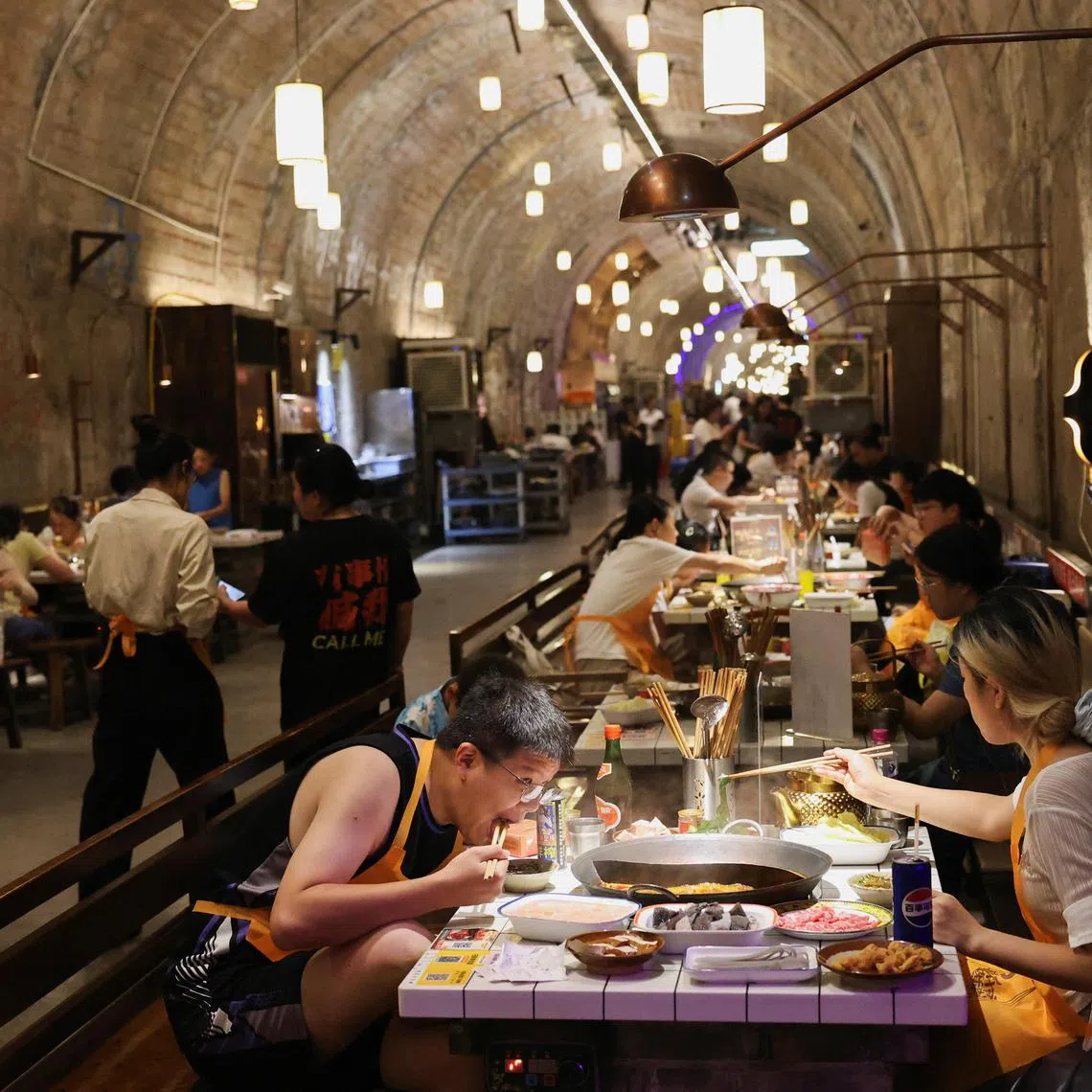Diners at Chongqing’s Underground Zhicheng Old Hot Pot restaurant, converted from a World War II-era air raid shelter, on July 31. 