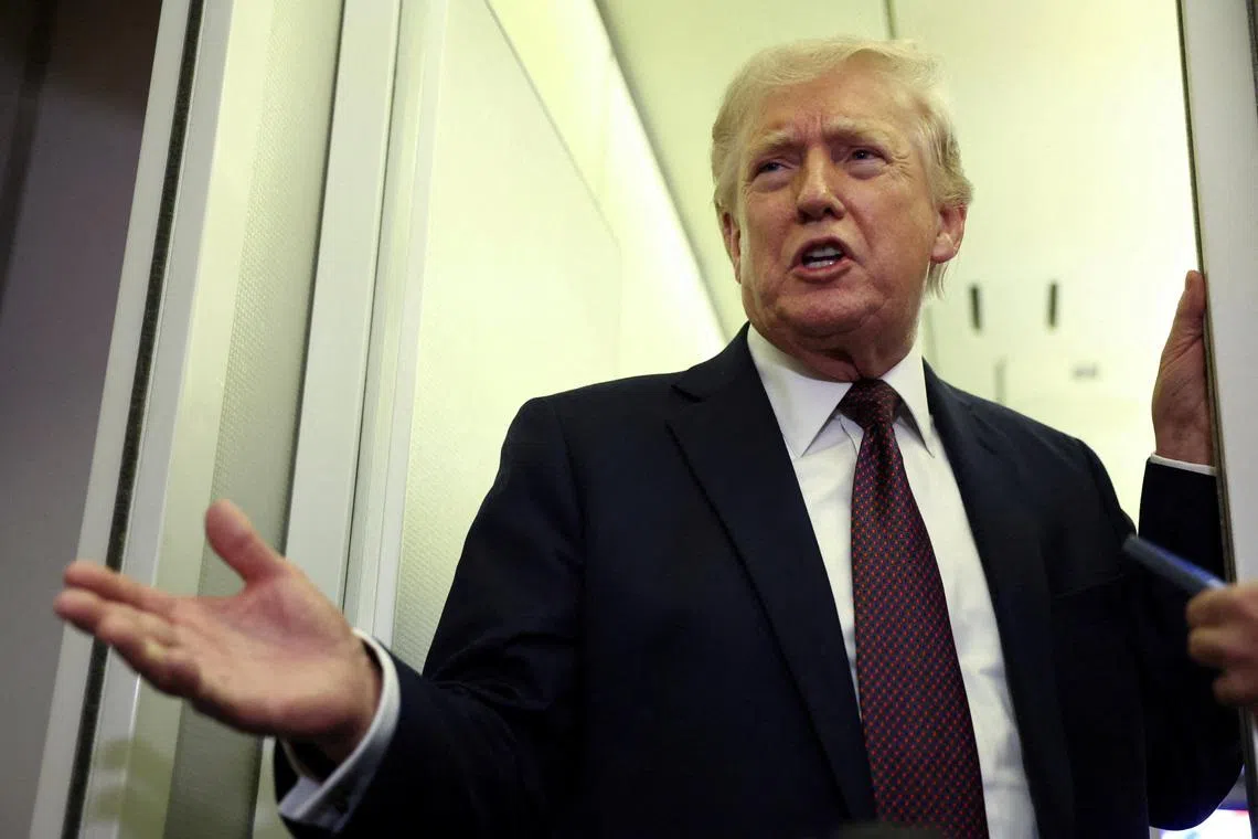 FILE PHOTO: U.S. President Donald Trump speaks to reporters aboard Air Force One on a flight back to Washington March 15, 2026. REUTERS/Kevin Lamarque/File Photo