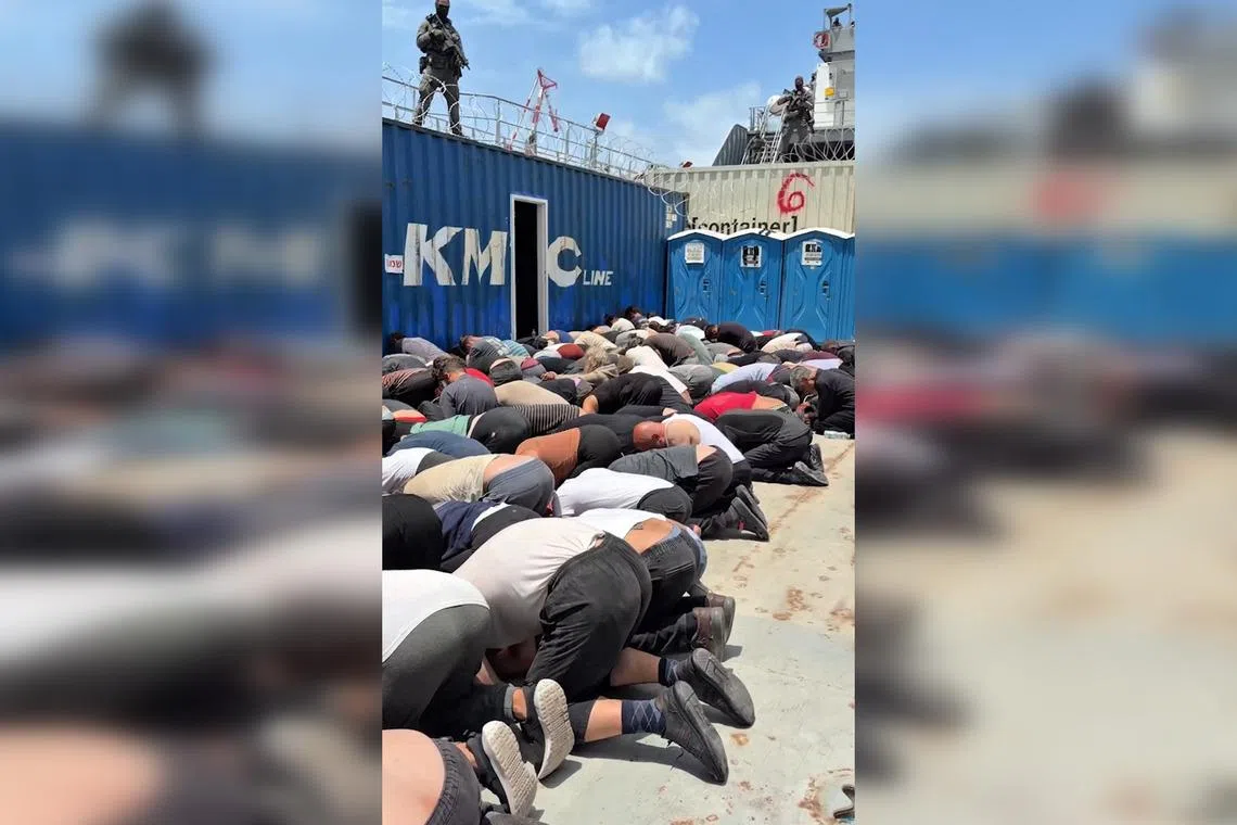 A screen grab taken from footage released on X in May by Israel's National Security Minister Itamar Ben Gvir showing dozens of detained flotilla activists kneeling with their hands tied behind their backs and their foreheads on the ground on the deck of an Israeli military boat.