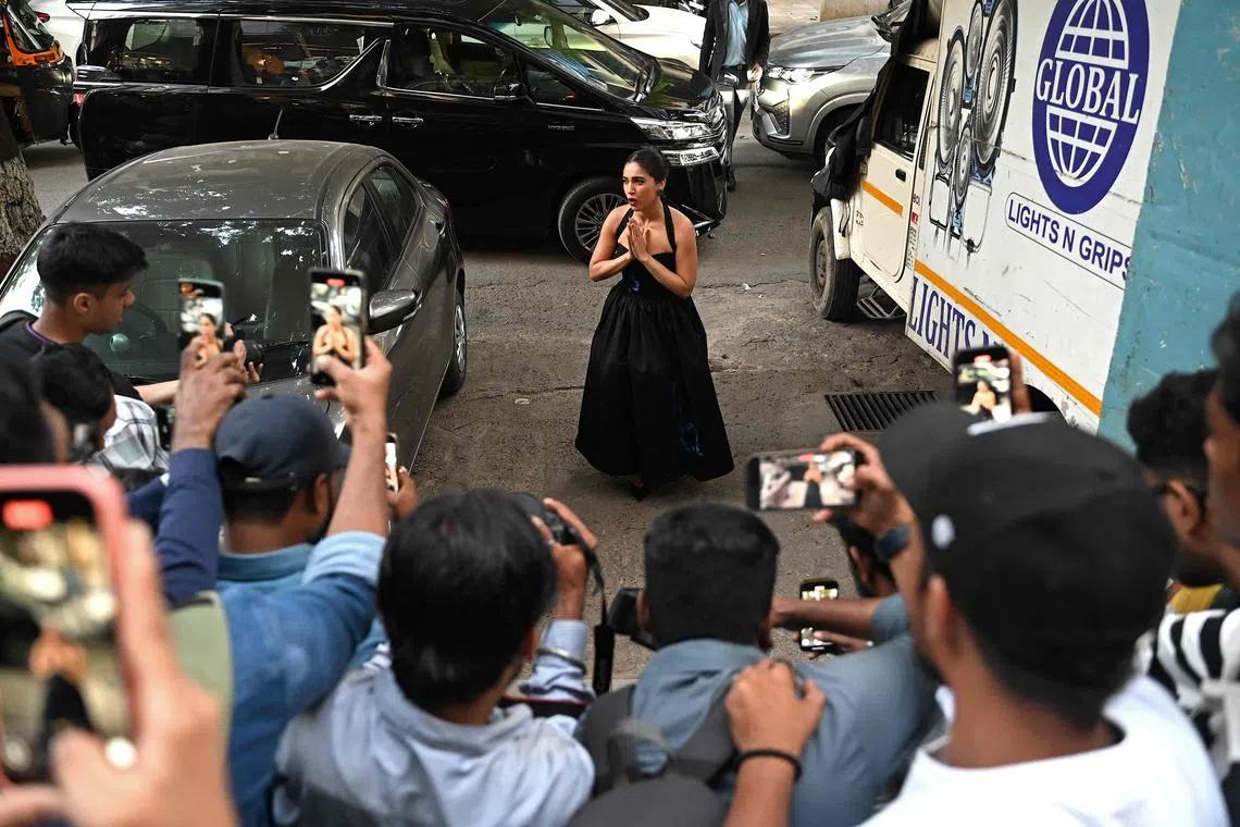 In this photograph taken on November 25, 2024, paparazzi photographers take pictures and videos of Bollywood actress Bhumi Pednekar, outside a hotel in Mumbai. (Photo by Sujit JAISWAL / AFP)