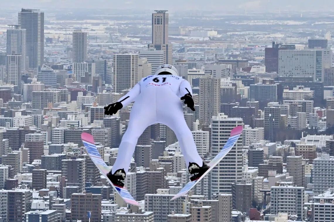 This photo taken on Jan 20, 2023 shows a ski jumper taking flight as the city of Sapporo is seen during the Ski Jumping World Cup competition.