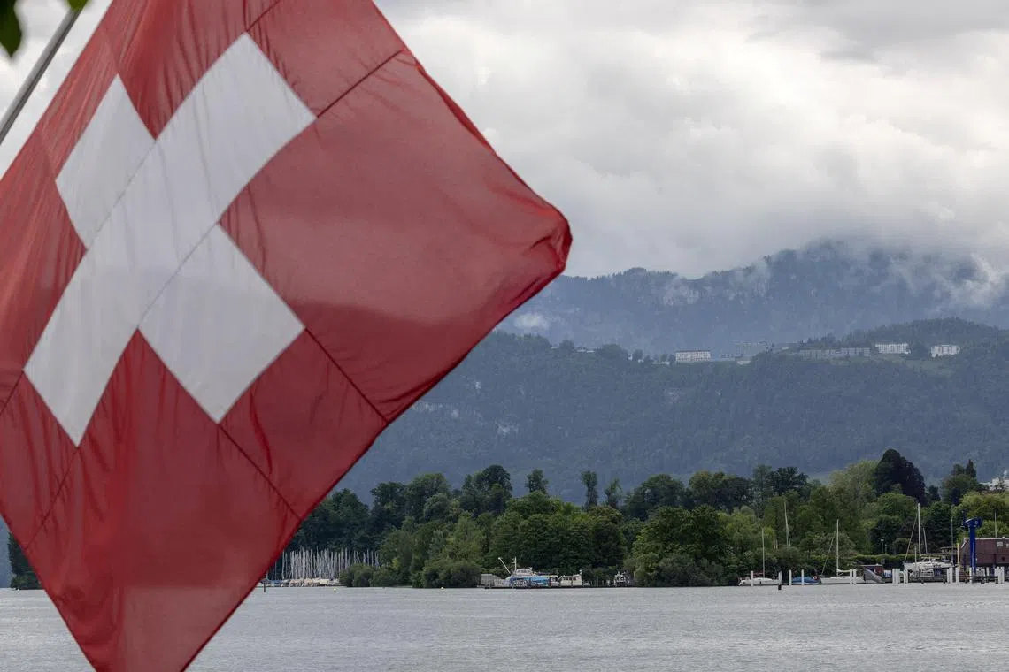 FILE PHOTO: A Swiss flag is pictured in front of the Burgenstock Resort where the Summit on Peace in Ukraine will take place June 15 and 16, in Lucerne, Switzerland, May 28, 2024.  REUTERS/Denis Balibouse/File Photo