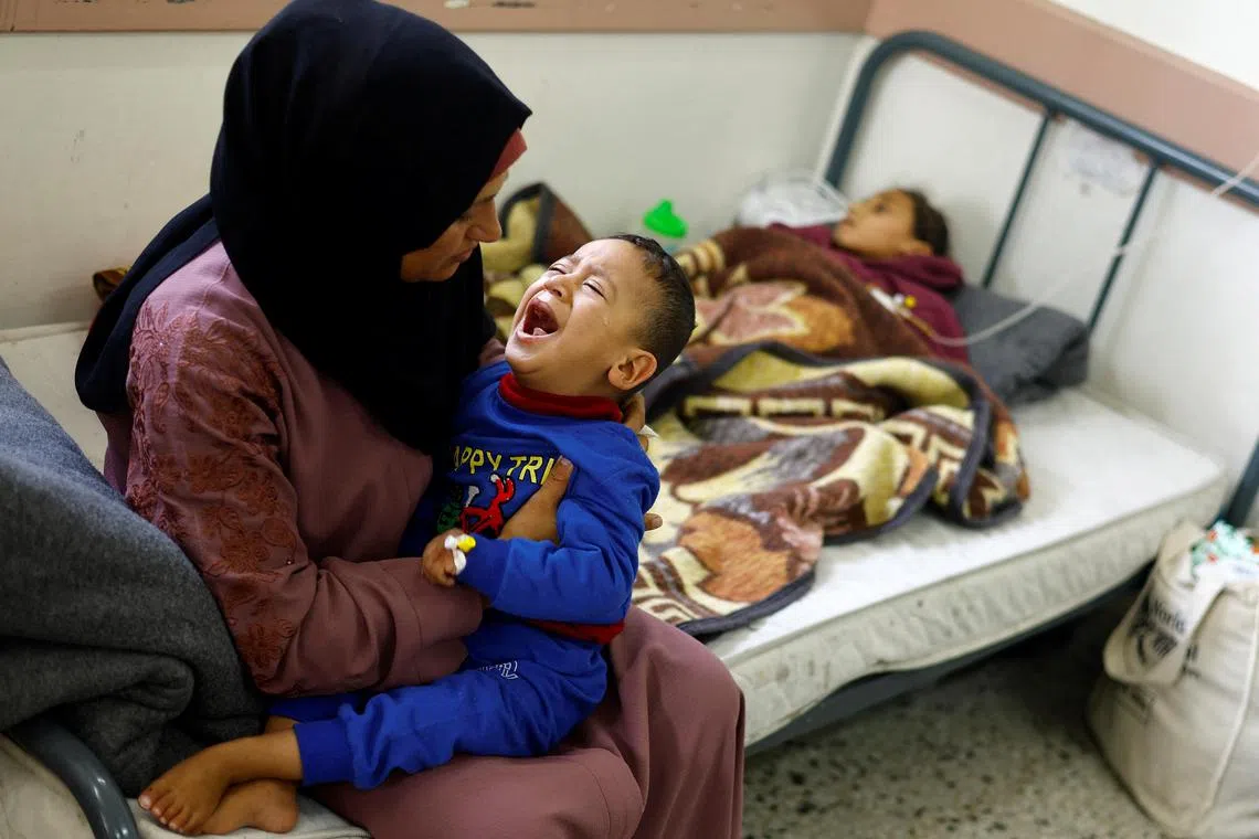 A Palestinian woman holds her son who suffer from malnutrition at the al-Awda health centre in Rafah on April 1, amid widespread hunger.