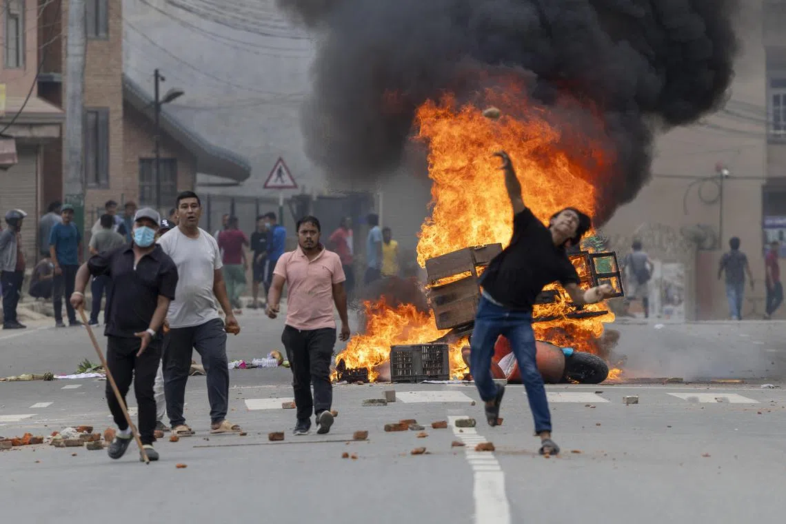 People stand near burning barricades during protests in Kathmandu, Nepal on Sept 9,2025