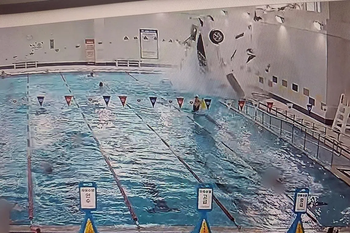 The car flipped over after landing in the water, and swimmers nearby quickly jumped in to help the driver.