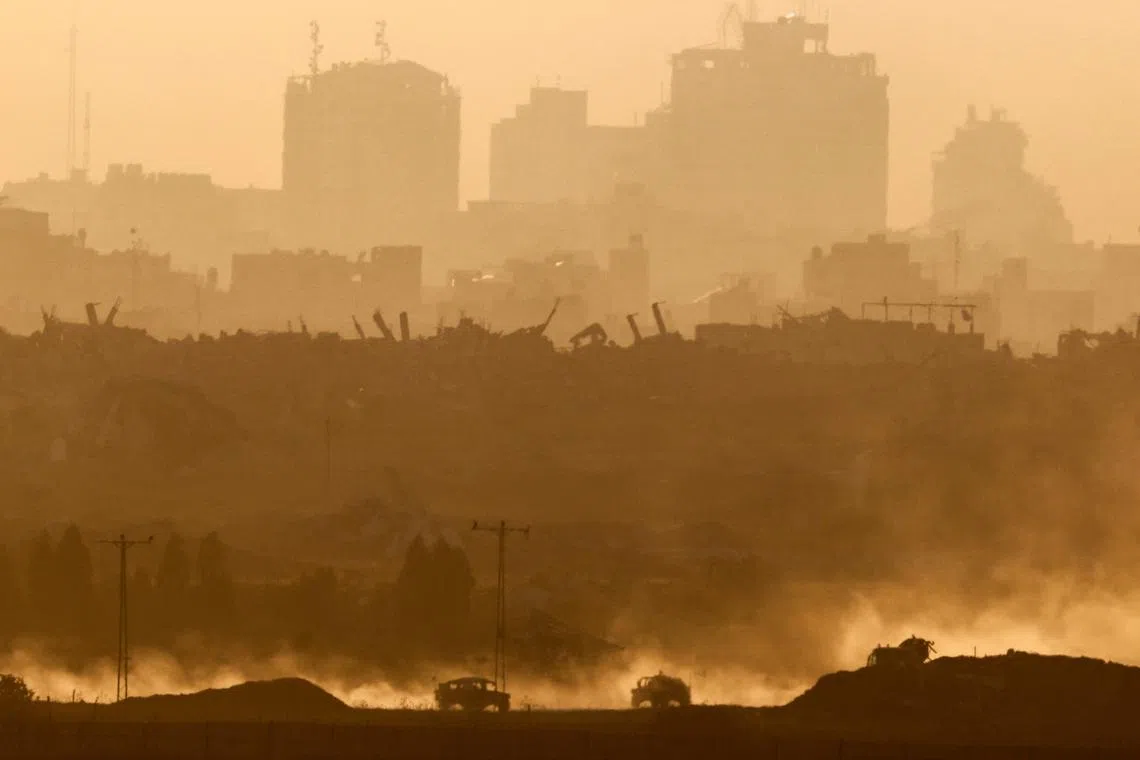 FILE PHOTO: Military vehicles manoeuvre in Gaza, as seen from the Israeli side of the border, June 11, 2025. REUTERS/Amir Cohen/File Photo