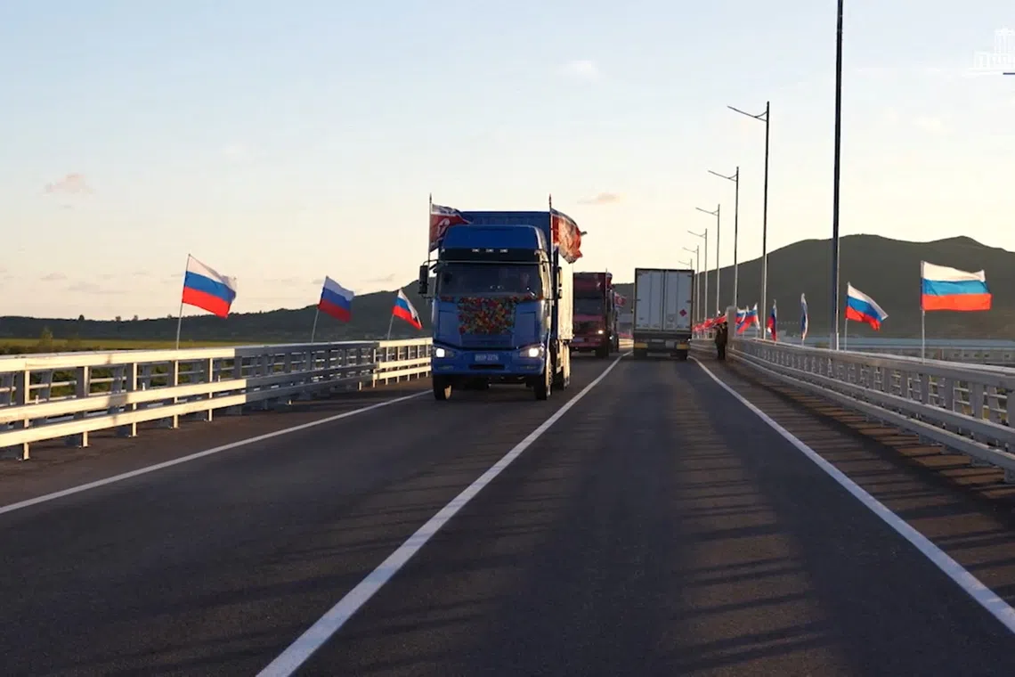 Trucks drive along a road during a ceremony opening the first road bridge between Russia and North Korea across the Tumen River, locally known as Tumannaya, on the border with North Korea in the Primorsky region, Russia, September 7, 2026, in this still image taken from a video. Russian Government/Handout via REUTERS