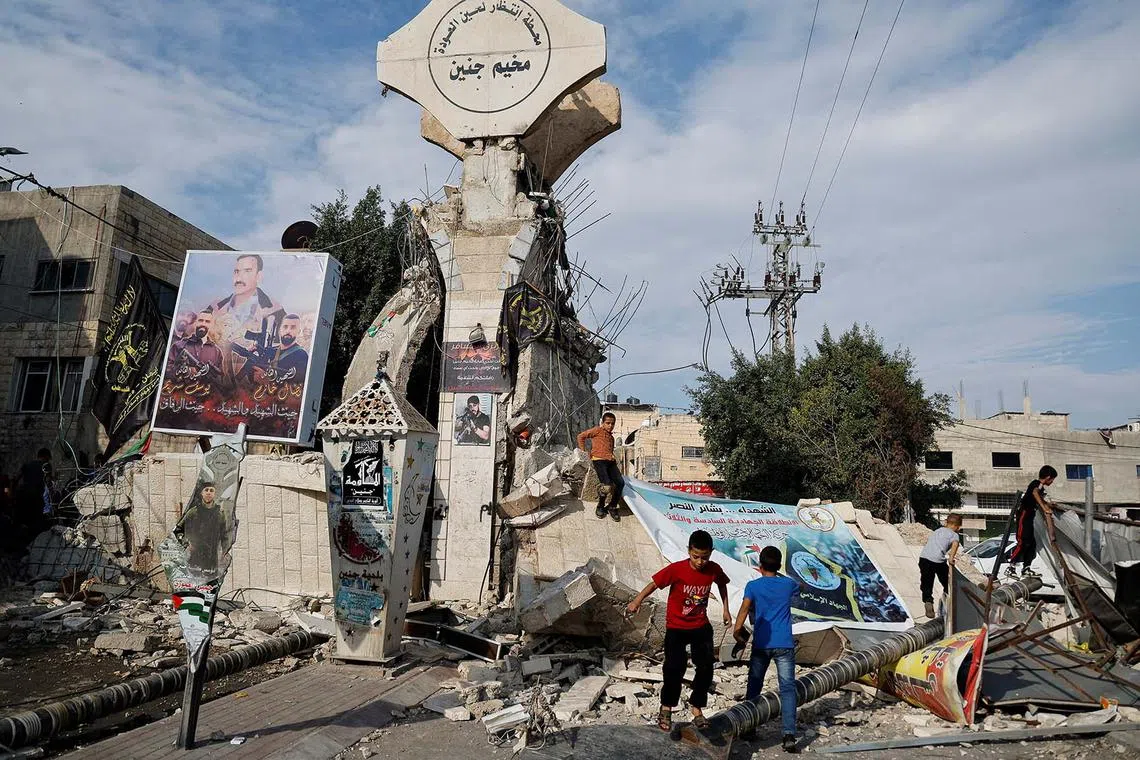 Palestinian children play on a damaged street, following an Israeli raid in Jenin, at the Jenin refugee camp, in the Israeli-occupied West Bank, Oct 30.