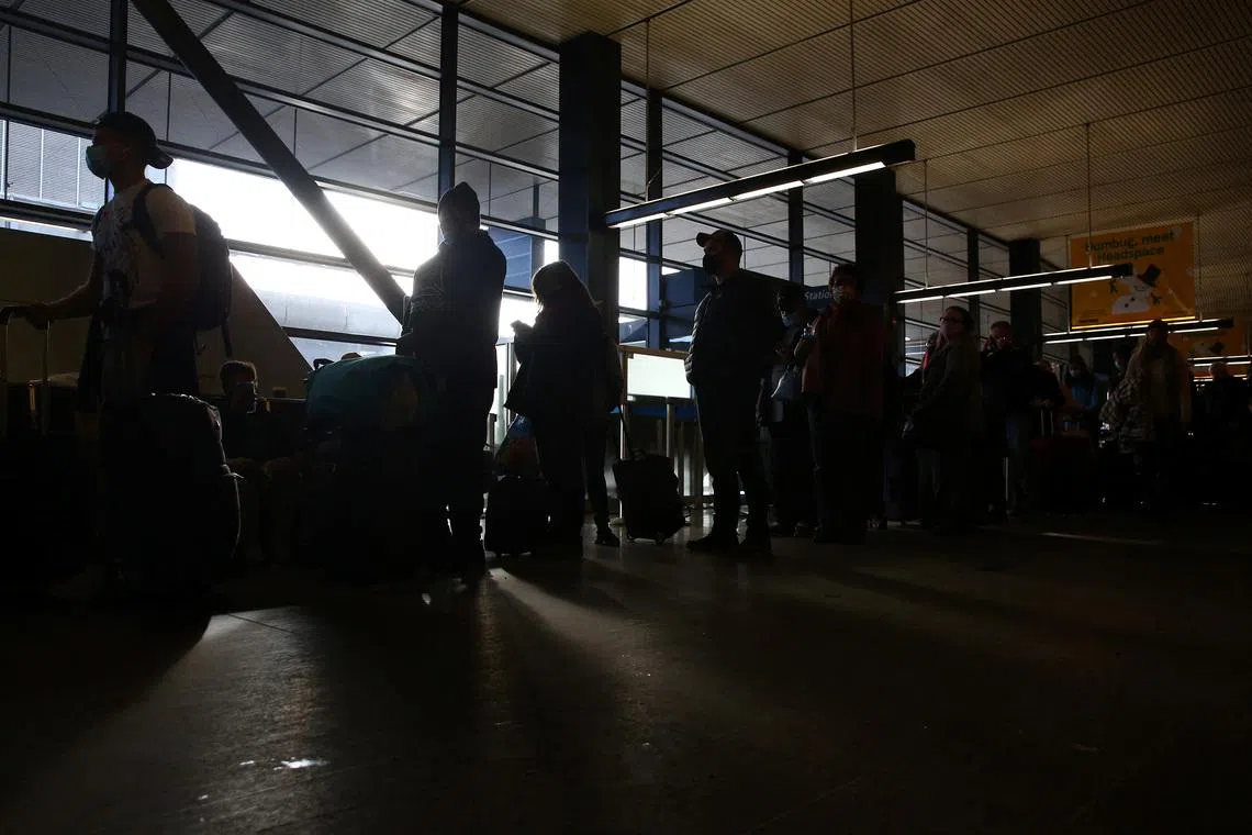 FILE PHOTO: People wait in a long assistance line at Seattle-Tacoma International Airport (Sea-Tac) in Seattle, Washington, U.S. December 27, 2021. REUTERS/Lindsey Wasson/File Photo