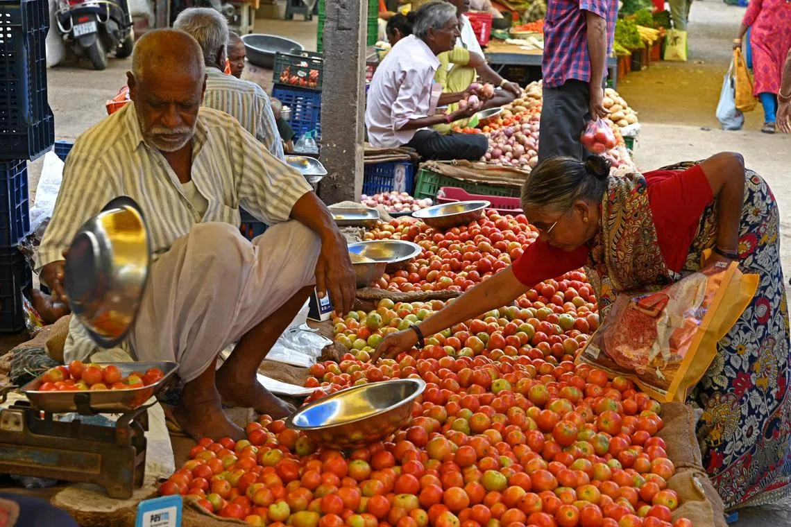 A customer buys tomatoes at a vegetable market in Hyderabad on July 4, 2023. 