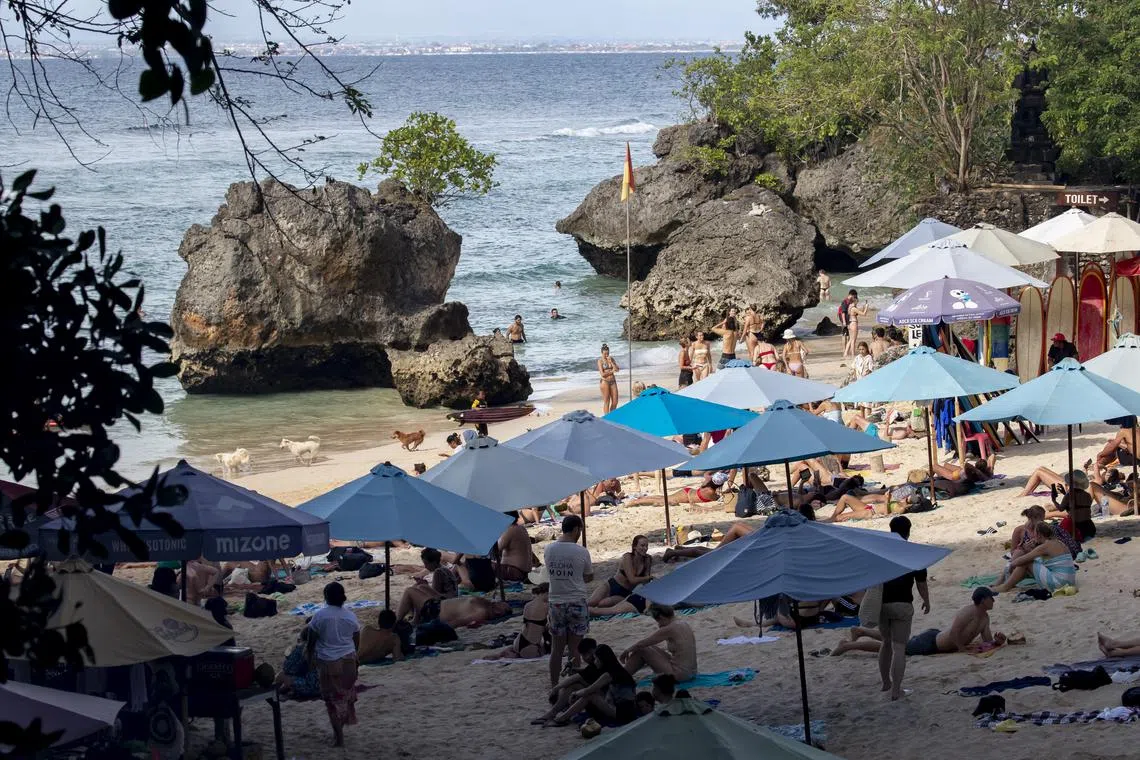 epa10399752 Tourists lie on a beach in Padang Padang, Bali, Indonesia, 11 January 2023. The Indonesian Tourism Ministry said the country will be ready to welcome tourists from China following the border reopen on 08 January 2023. EPA-EFE/MADE NAGI