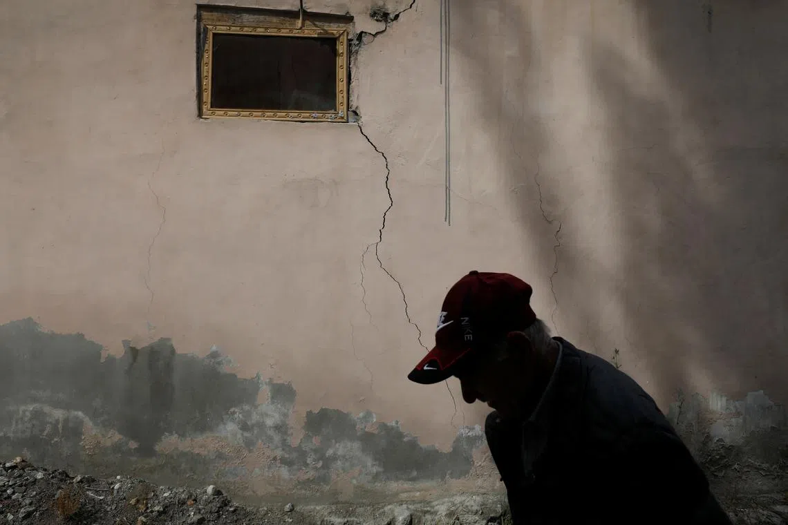 Akbar Hussain, 60, who runs a tea shop, walking past a wall of a house that was damaged after a Glacial Lake Outburst Flooding (GLOF) incident, in Hassanabad village, Hunza valley, in the Karakoram mountain range in the Gilgit-Baltistan region of Pakistan, Oct 9, 2023. With the U.N.'s COP28 climate summit scheduled to begin on Nov. 30, pressure is ramping up on wealthy countries to fulfil promises to help developing nations.  