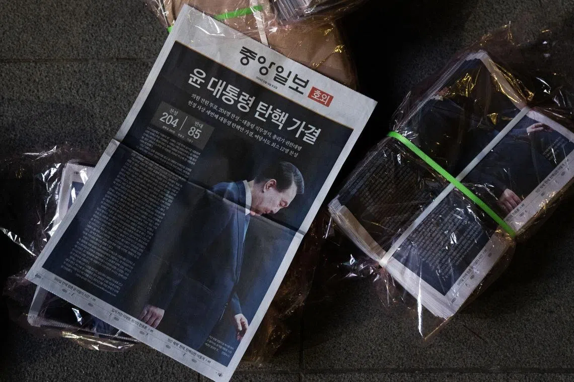 Copies of a special edition of the JoongAng Ilbo newspaper, featuring a front page report on South Korean President Yoon Suk Yeol's impeachment, on a street in Seoul, on Dec 14.