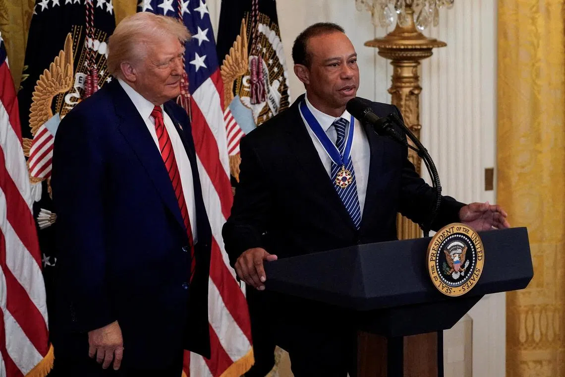 Tiger Woods speaks next to US President Donald Trump during a reception honouring Black History Month in the East Room of the White House in Washington.