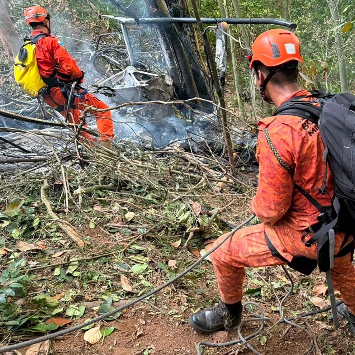 Firefighters working to put out a blaze after a helicopter crashed on Aug 8, killing four people, in Rio’s Tijuca National Park.