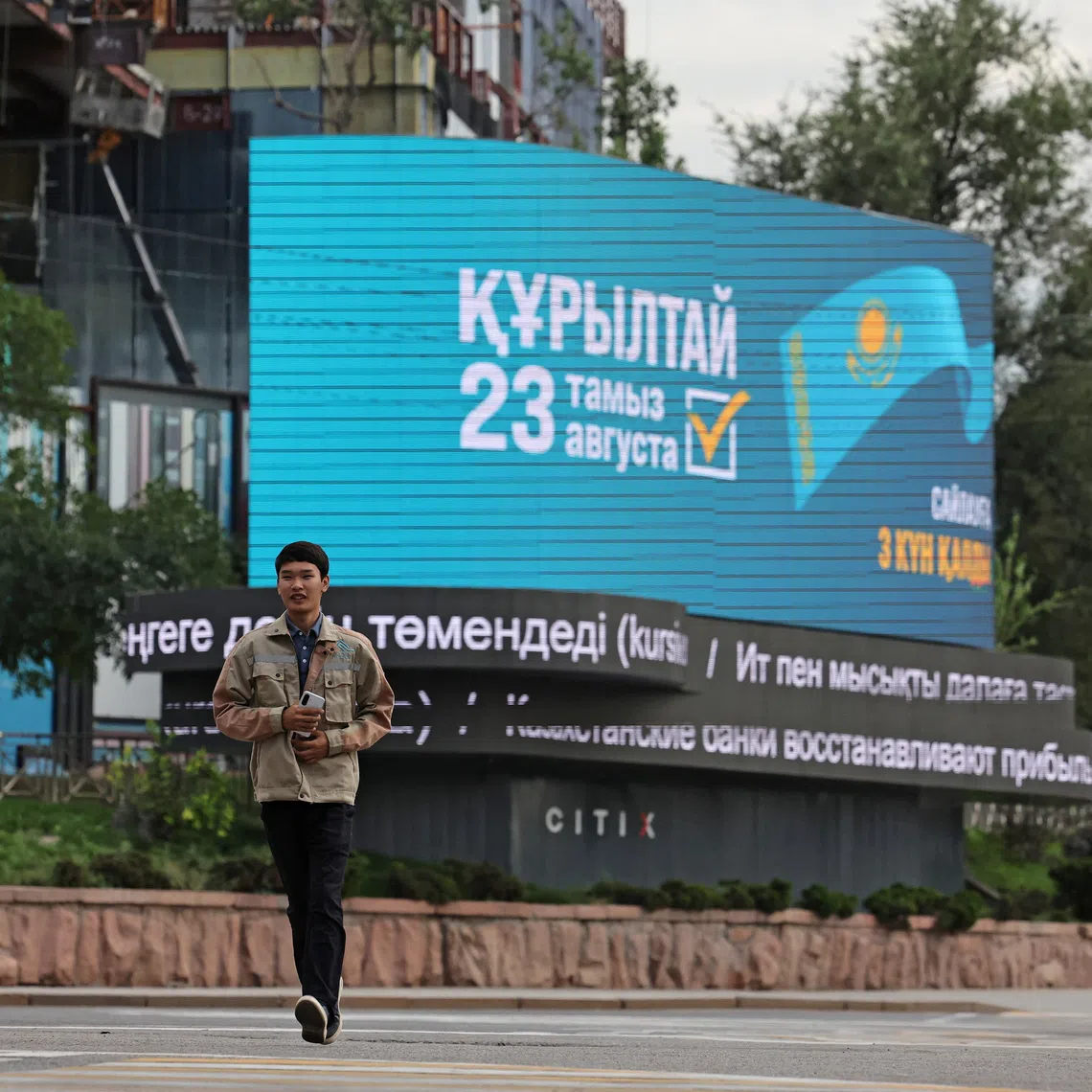 A pedestrian walks past an electronic screen announcing Kazakhstan's upcoming snap parliamentary election in Almaty, Kazakhstan, August 20, 2026. REUTERS/Pavel Mikheyev