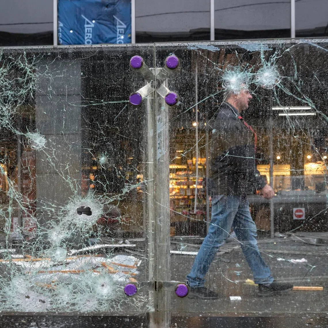 A person walking past the site of a Russian missile strike on a shopping mall in Kyiv, Ukraine, on Oct 19.