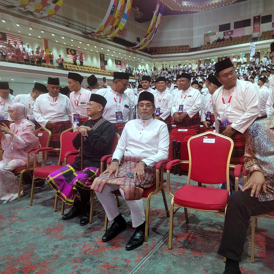 Former health minister Khairy Jamaluddin (seated, in white) was greeted warmly by UMNO Youth members at the wing's general assembly after a three-year absence.