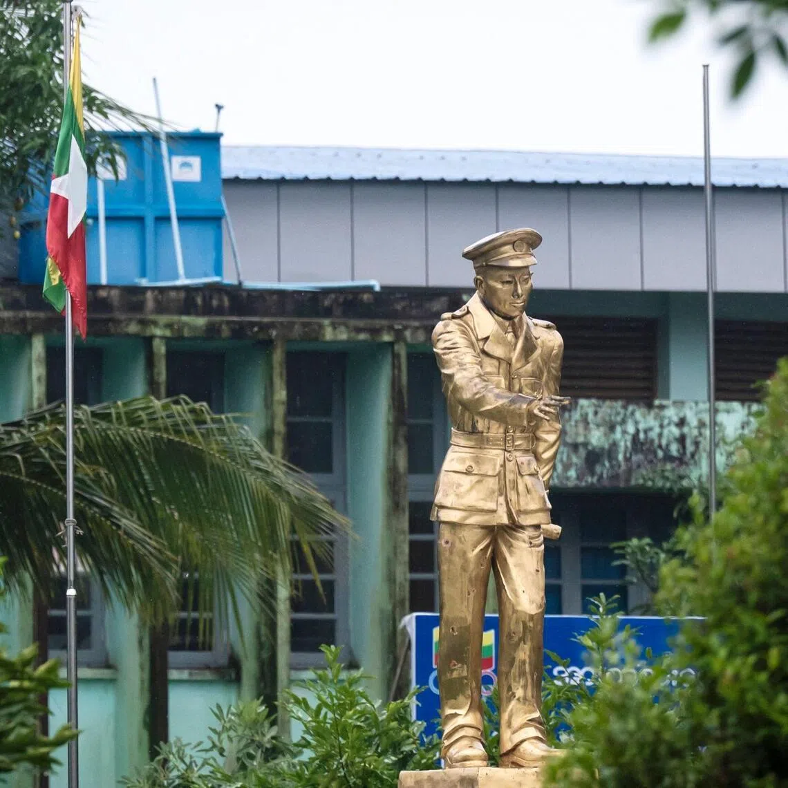 A national flag is raised next to a statue of Myanmar’s independence hero General Aung San at Thu Mingalar Park in Yangon, on July 16.