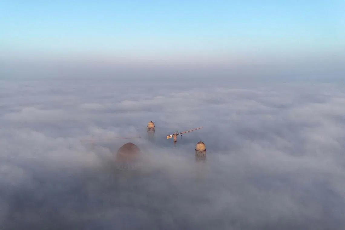 An aerial view showing fog surrounding the Mosul Grand Mosque in the northern Iraqi city early on Dec 28, 2023. 