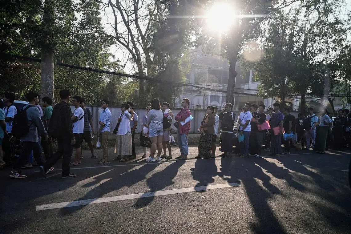 People stand in line to get visas at the embassy of Thailand in Yangon on February 16, 2024, after Myanmar's military government said it would impose military service. 