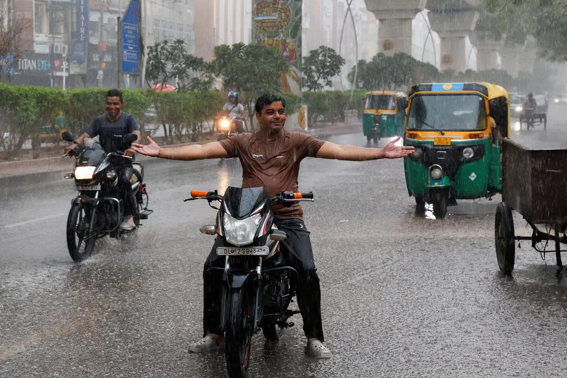 A man reacts during rainfall as the temperature dips in the capital upon the arrival of monsoon, which was struggling with heatwave in the past weeks, in New Delhi, India, June 27, 2024. REUTERS/Priyanshu Singh