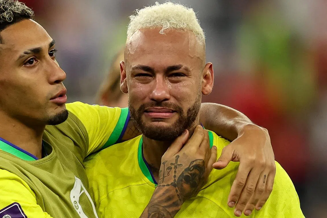Brazil forward Neymar (right) is consoled by team-mate  Raphinha after the Selecao bowed out of the World Cup on Friday. 