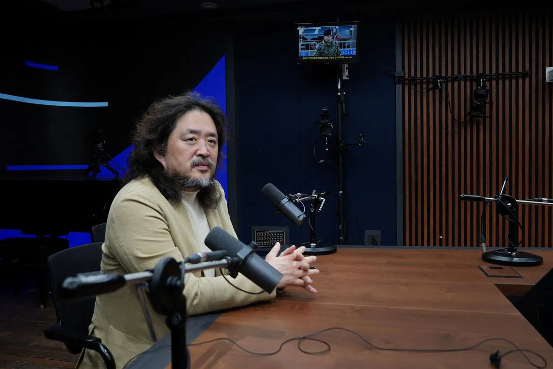 South Korean journalist Kim Ou-joon poses for photographs after an interview with Reuters at his recording studio in Seoul, South Korea, December 9, 2024. REUTERS/Joseph Campbell