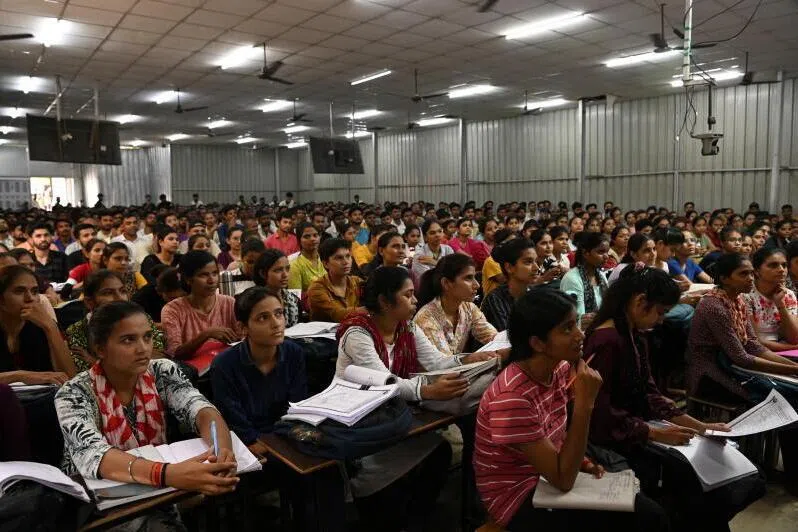 Students attend a class at a coaching institute training students to secure government jobs, in Prayagraj, India.