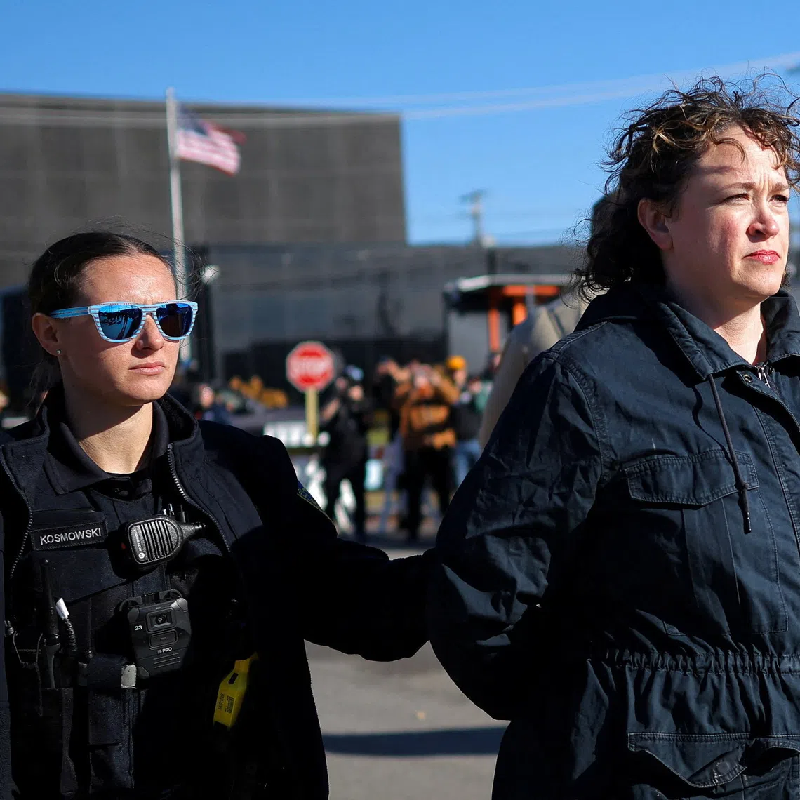 An officer from Broadview Police Department detains a woman during a protest against immigration actions, outside the Broadview ICE facility in Chicago, Illinois, U.S., November 7, 2025. REUTERS/Carlos Barria