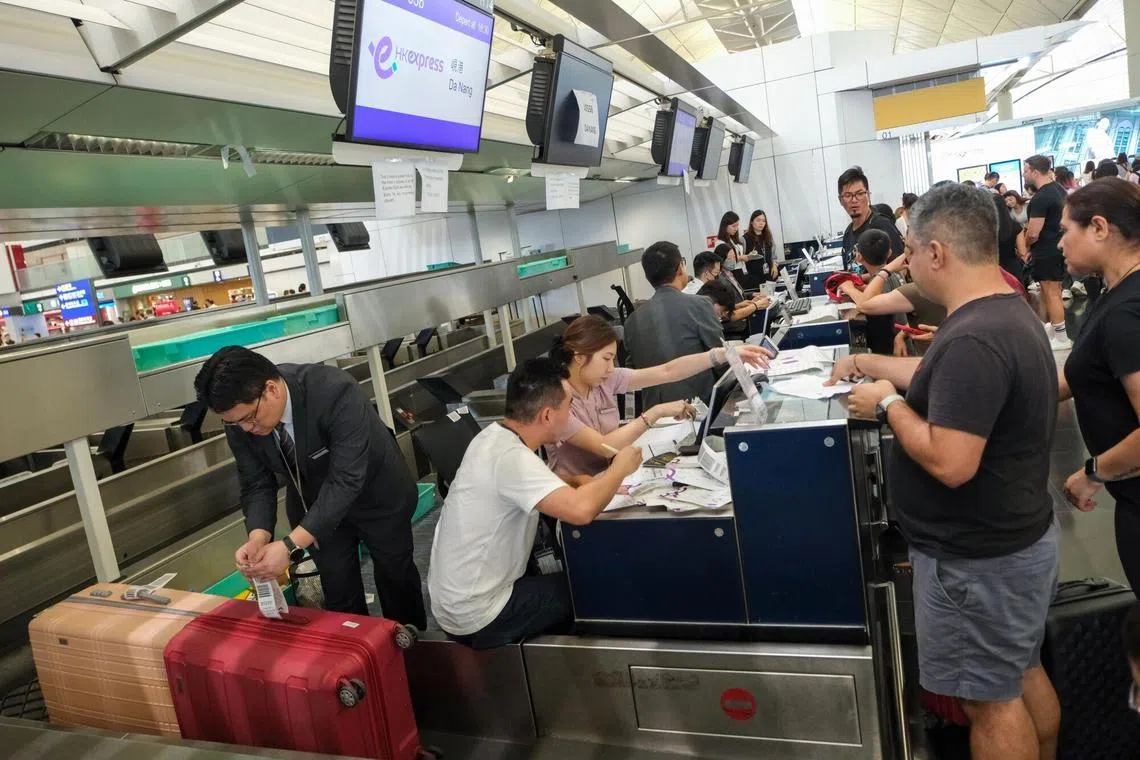 Employees assisting travelers at check-in counters for Hong Kong Express Airways Ltd. during a worldwide systems outage at Hong Kong International Airport in Hong Kong on  July 19, 2024. A series of technical glitches disrupted services at airlines, banks, and the London Stock Exchange on Friday, in an unusually widespread cascade of failures that spread from the US to Asia after Microsoft Corp. reported an outage across its online services.