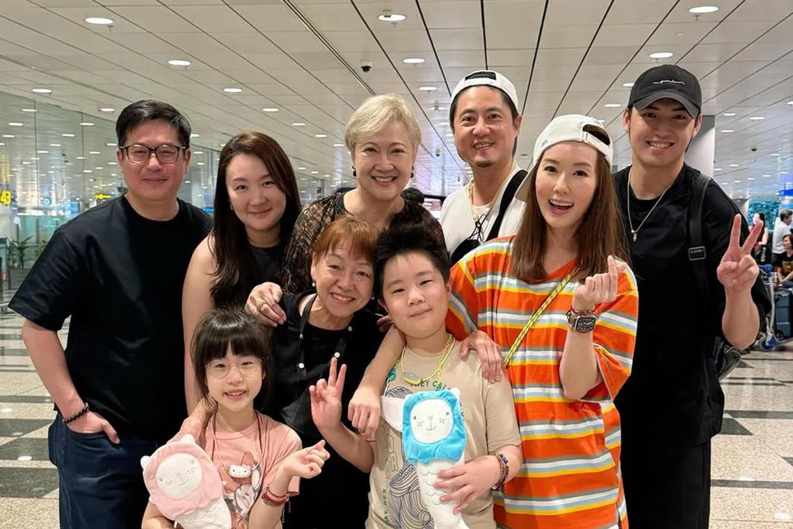 Yvonne Lim and her husband Alex Tien (both wearing white caps) with their children AJ and Alexa (front row), and actress Hong Huifang (back row, centre).