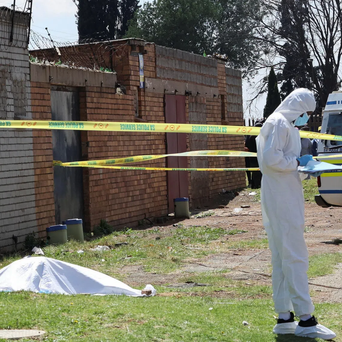 A forensic investigator near a cordoned-off crime scene where the body of one of the several women killed was found in Ekurhuleni, South Africa, on Sept 15.