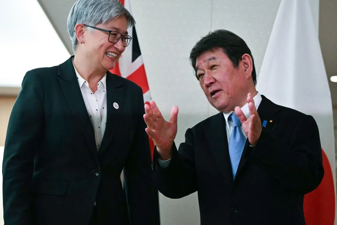 Japanese Foreign Minister Toshimitsu Motegi (right) speaks to Australian Foreign Minister Penny Wong at the Foreign Ministry in Tokyo on April 28.