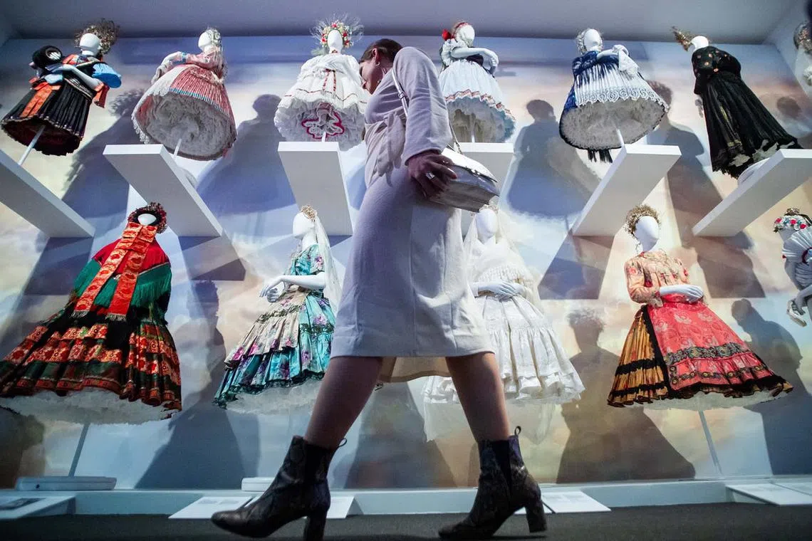 A woman walking past a temporary exhibition, The Hungarian Bride, on its opening day in the Hungarian National Museum in Budapest, Hungary, Dec 13, 2023. 