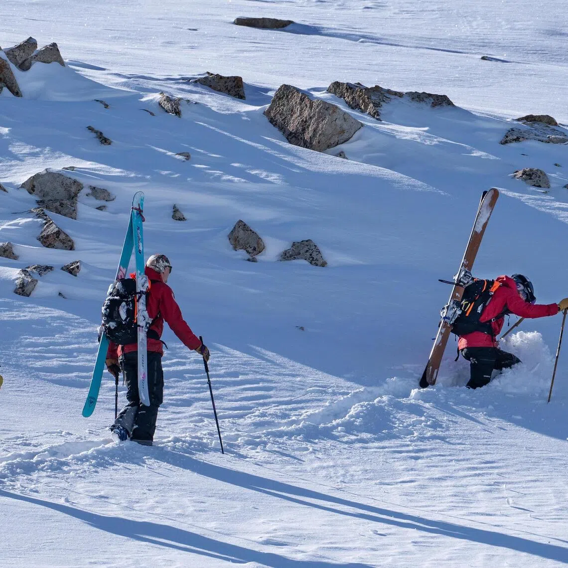 Ski patrollers hike towards a high ridge to determine if the area can be safely opened to skiers for the next day, at Snowbird, a ski resort near Alta, Utah.