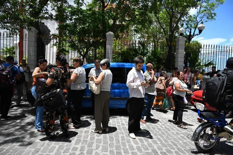 Workers checking their cell phones after a tremor caused by a magnitude-6.0 earthquake in Havana, on June 8, 2026.