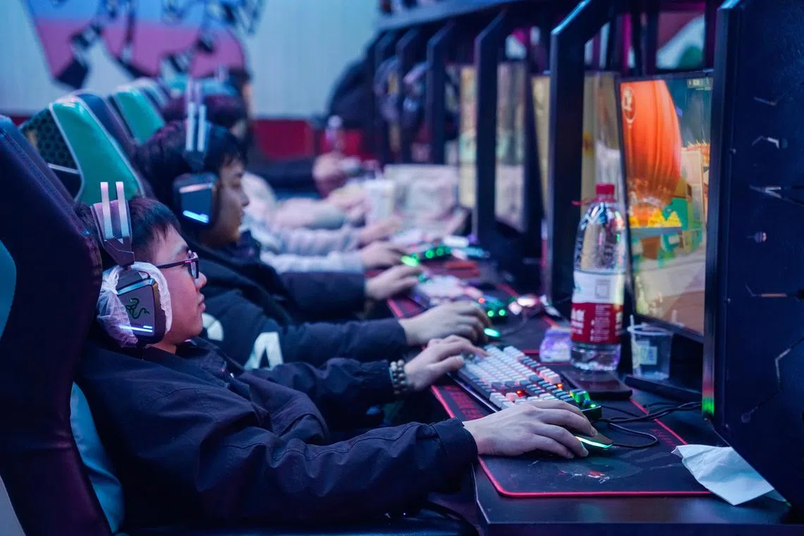 People play video games at an internet cafe in Beijing on Jan 22, 2024.