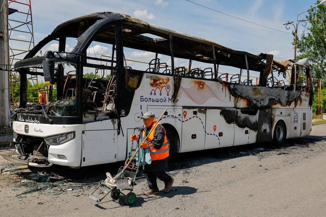 A worker walks at the site of a Ukrainian drone attack on a bus, according to local authorities in the course of the Russia-Ukraine military conflict, in the settlement of Yenakiievo in Donetsk region, a Russian-controlled part of Ukraine, June 3, 2026.  REUTERS/Alexander Ermochenko