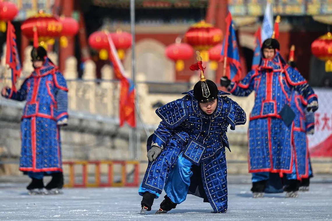 Actors dressed as imperial soldiers performing 'ice play', one of the traditional ice sports of the royal family during the Qing Dynasty, on a frozen lake at Beihai Park in Beijing on Dec 29, 2023. 