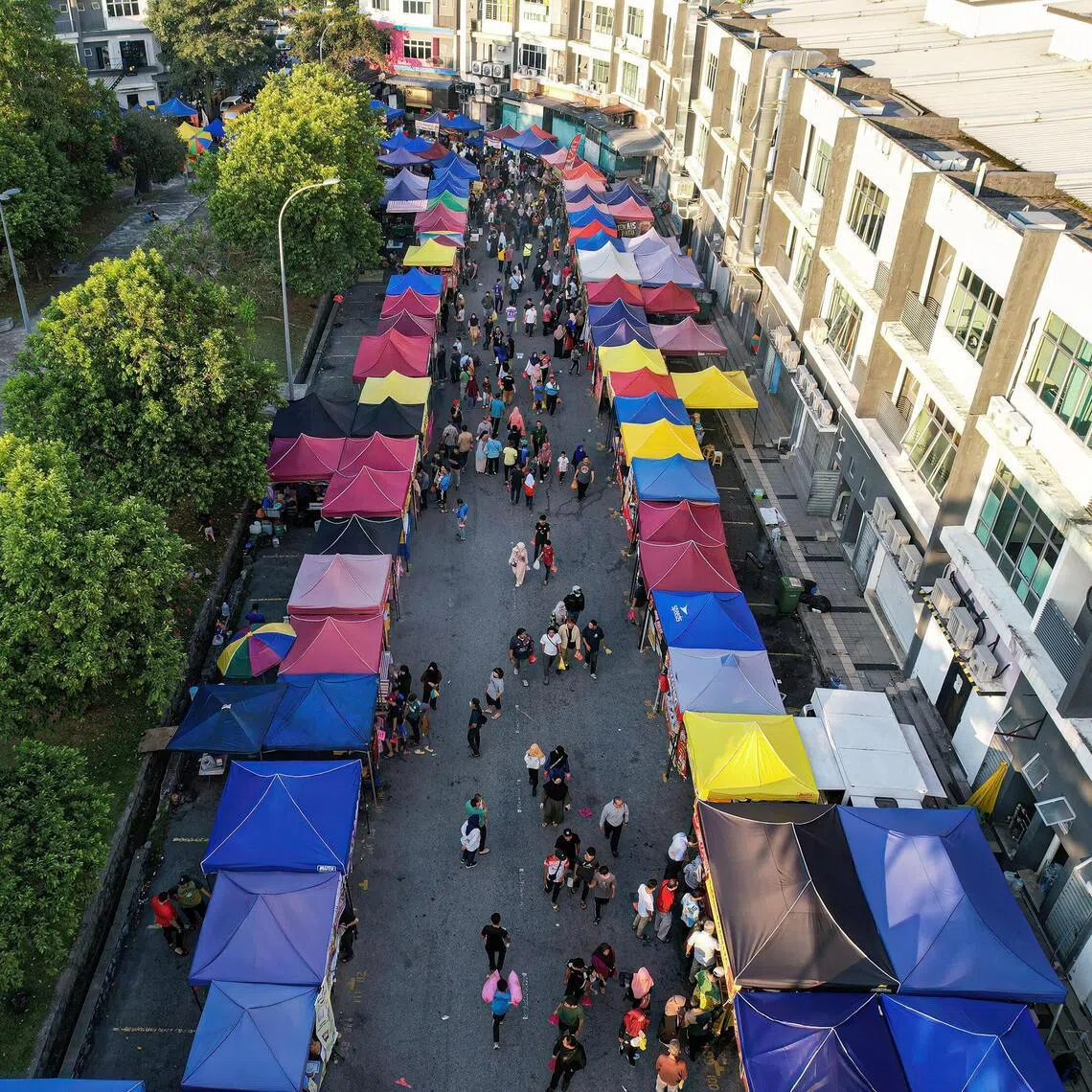Pedestrians walking down a road in Kajang, Malaysia. The district’s police chief Naazron Abdul Yusof said a woman whose body was found stuffed in a suitcase died from slash wounds to the head.