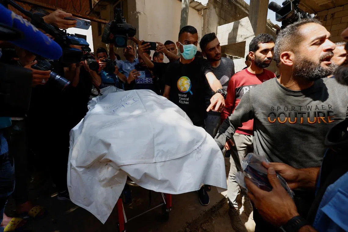 People carry the body of one of the foreign workers from the World Central Kitchen (WCK), who were killed in an Israeli airstrike, before they are transported to their families outside Gaza, amid the ongoing conflict between Israel and the Palestinian Islamist group Hamas, in Rafah, in the southern Gaza Strip April 3, 2024. REUTERS/Mohammed Salem