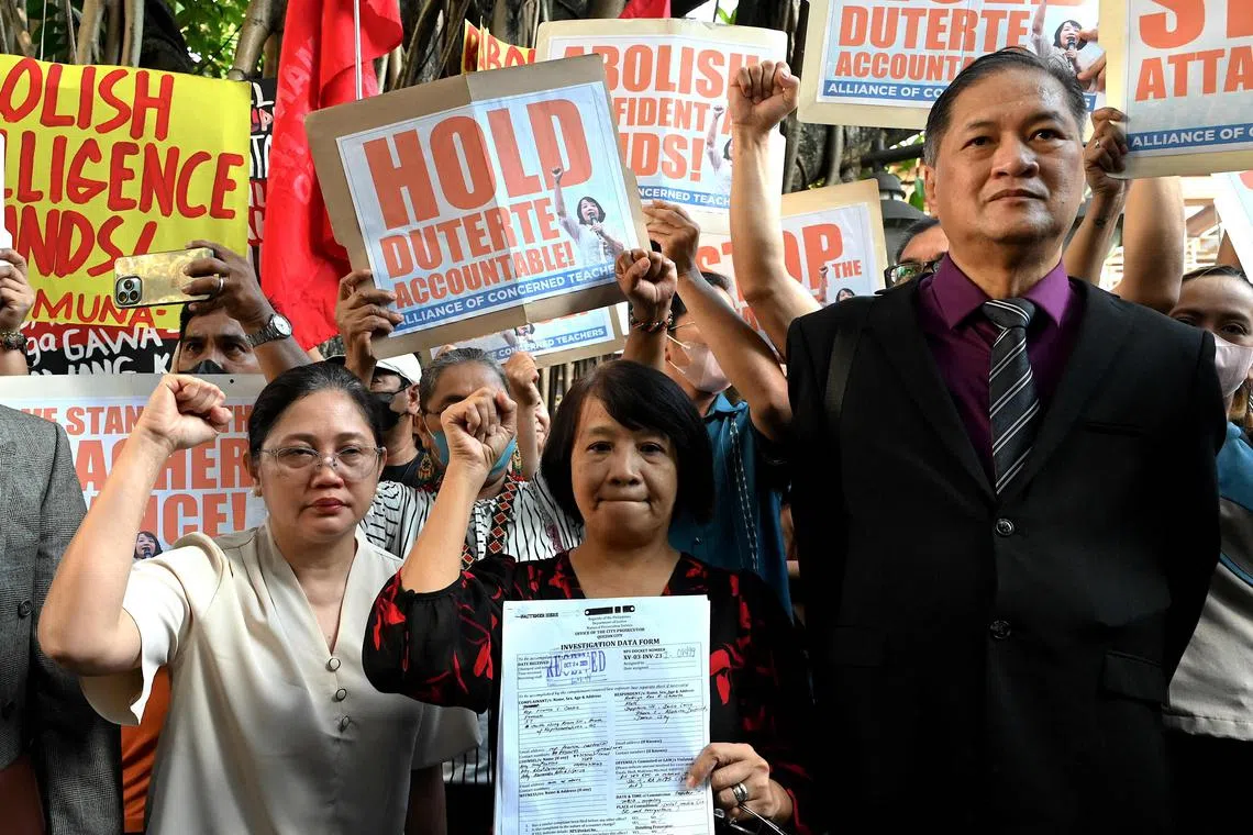 Philippine legislator France Castro (C) shows a document after filing a criminal complaint against former Philippine president Rodrigo Duterte.