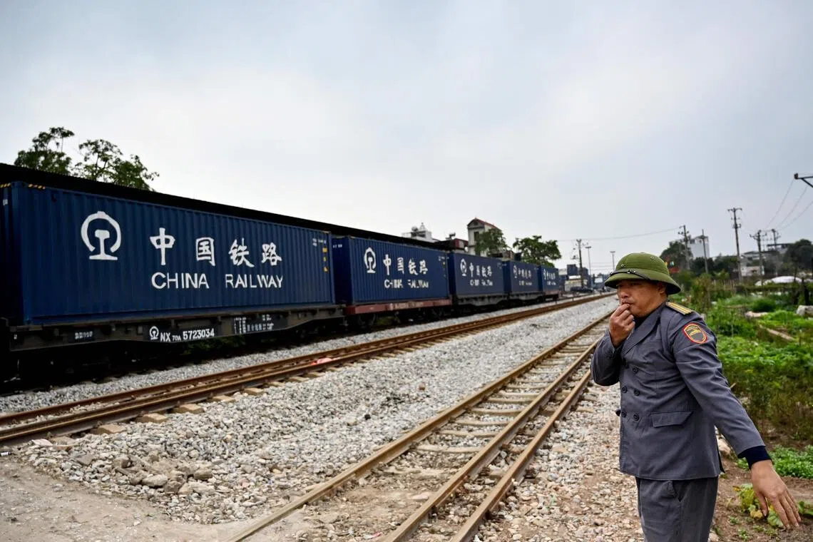 This photo taken on February 13, 2025 shows a railway worker guiding a train in Hanoi. Vietnam said February 19 that it will build a $8 billion rail link from its largest northern port city to the border with China, boosting links between the two Communist-ruled countries and making trade easier. (Photo by Nhac NGUYEN / AFP)