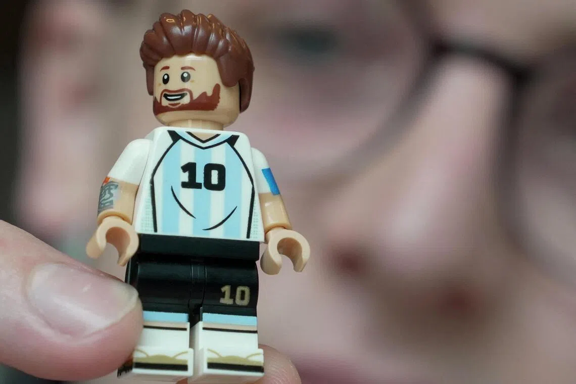 LEGO model designer Freddy Charters holds up a minifigure of Lionel Messi.  
