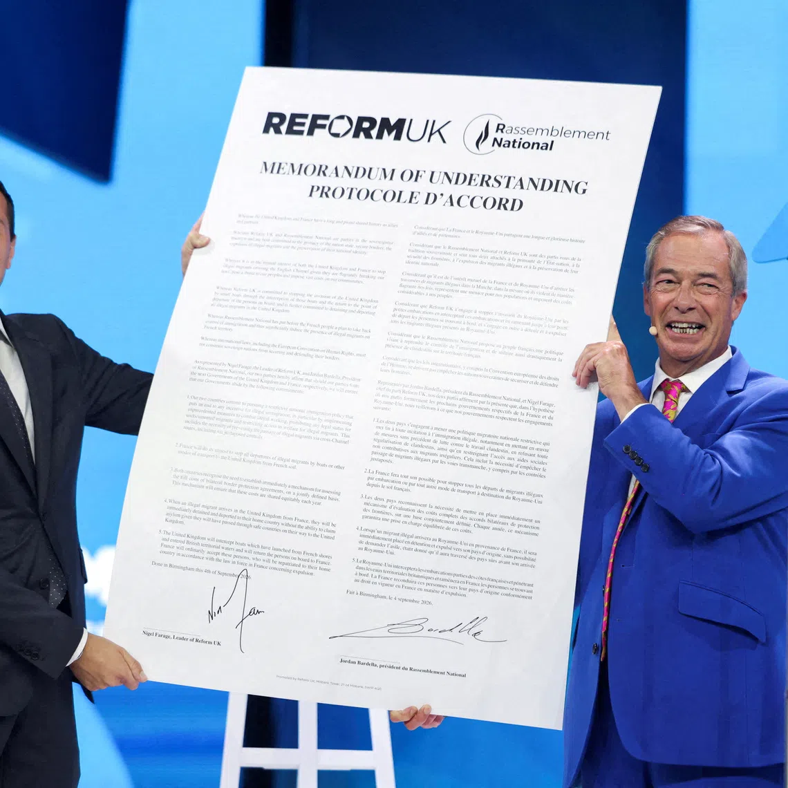 FILE PHOTO: Britain's Reform UK party leader and MP for Clacton, Nigel Farage, and President of the French far-right party Rassemblement National (RN), Jordan Bardella, react after signing a Memorandum of Understanding between the two parties during the Reform UK party conference in Birmingham, Britain, September 4, 2026. REUTERS/Temilade Adelaja/File Photo