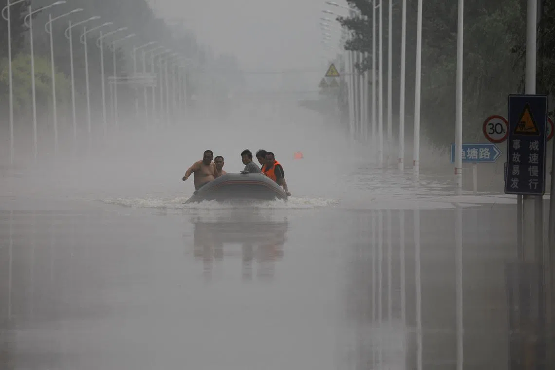 Rescuers take a rubber boat through a flooded street in Zhuozhou city, Hebei province, China.